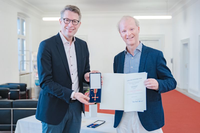 Bayerns Kunstminister Markus Blume (l.) überreicht Bundesverdienstkreuz an Musiker Kolja Lessing